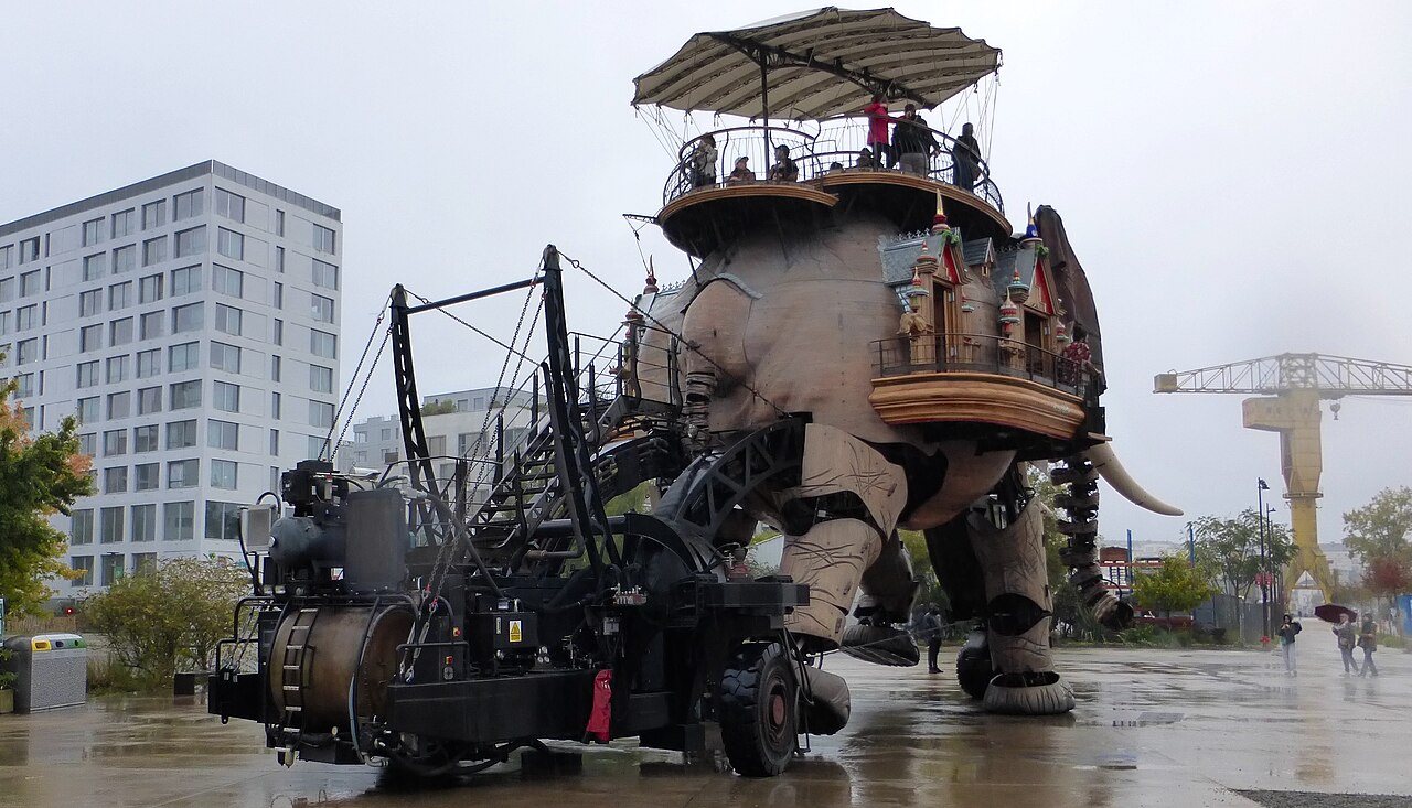 The Grand Éléphant walking along the quay, a harbor crane behind